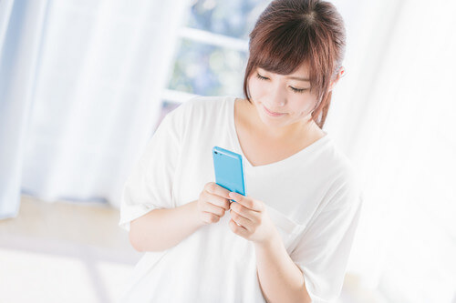 スマホをいじる女性